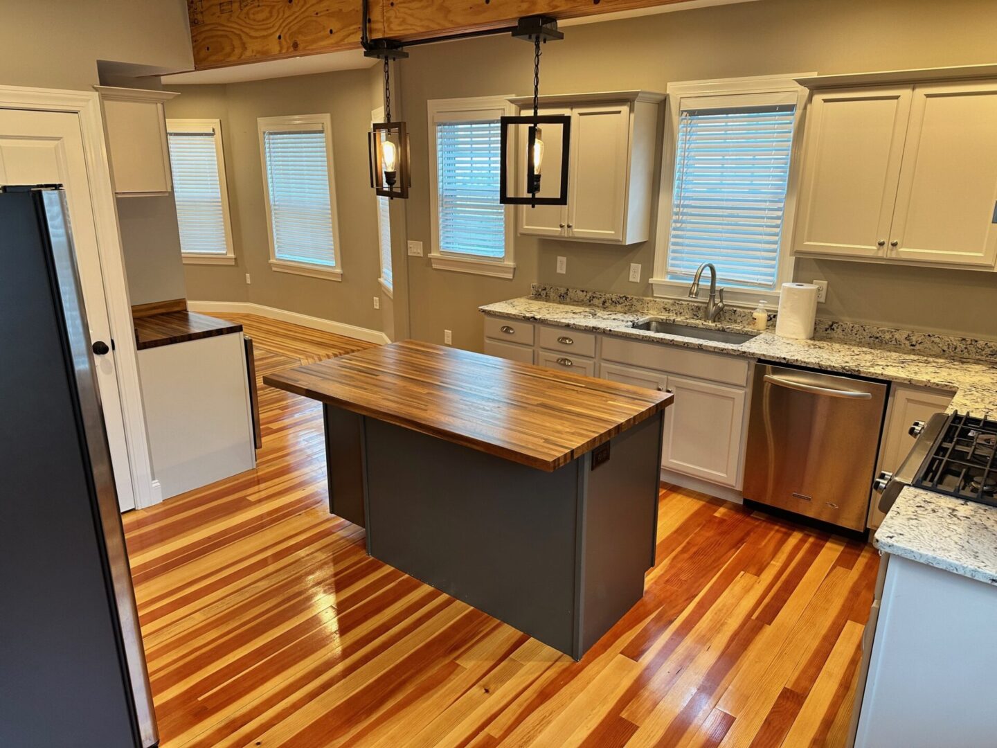 A kitchen with wood floors and wooden cabinets.