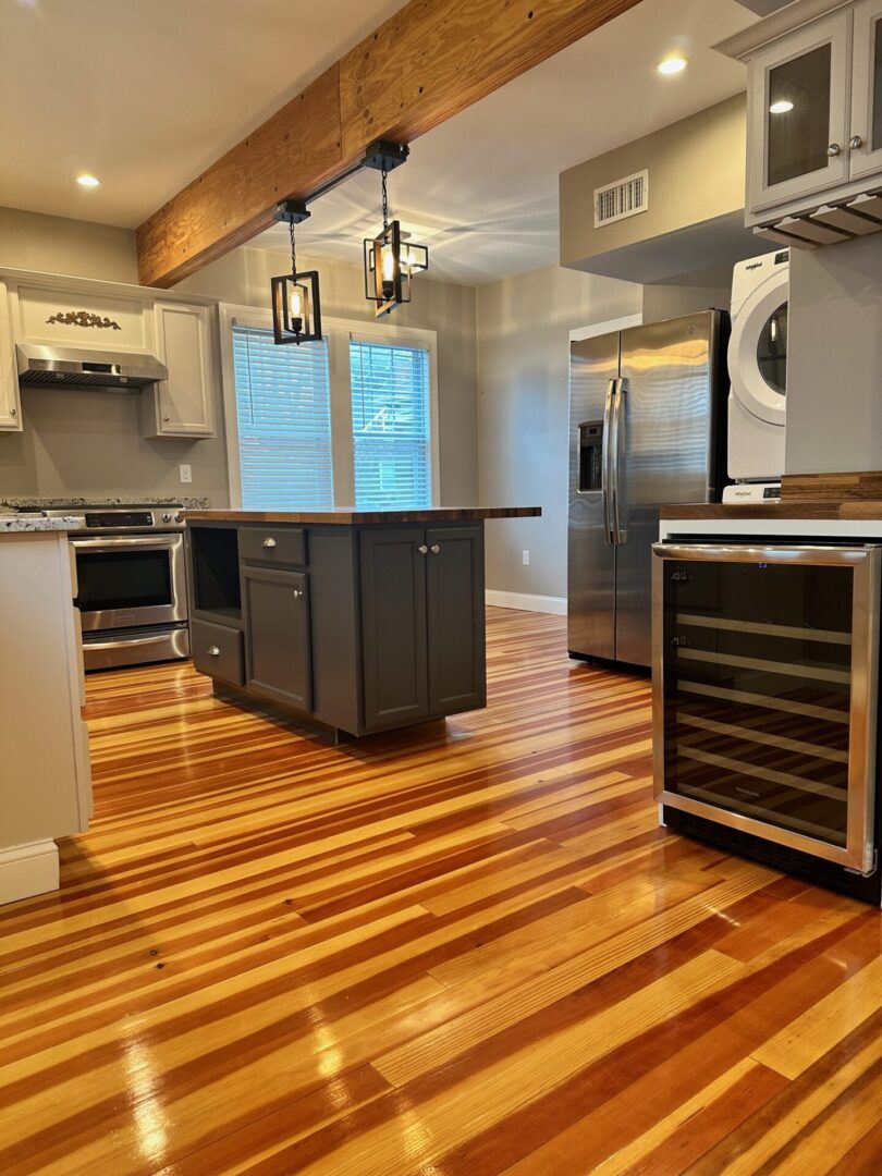 A kitchen with wood floors and stainless steel appliances.